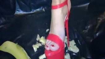 Hot red high heels crush a banana