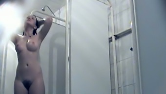 Busty brunette with hairy pussy washing in the shower room