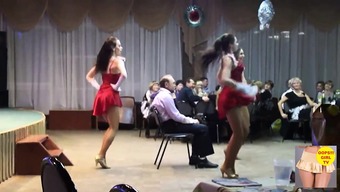 A pack of naughty girls dance around a guy sitting in a cha