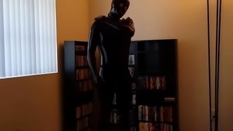 Stroking his cock in the library dressed as a gimp