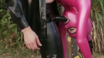 Latex wearing chick is sucking hard stick being hanged up side down