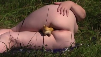 Voyeur in a public place caught a mature milf in the lens, who masturbates outdoors with a banana. Nudist with big tits, fat ass and hairy pussy.
