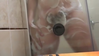 Pregnant milf in the lather in the shower masturbates with a dildo. Rubber dick fucks hairy pussy.