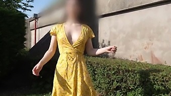 A 19-year-old brown-haired woman has an backside garment in a park.